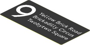 Sticker  1.2 x  2.6 with White "9", "Yellow Brick Road", "Brickadilly Circus" and "Twobytwo Square" on Black Background